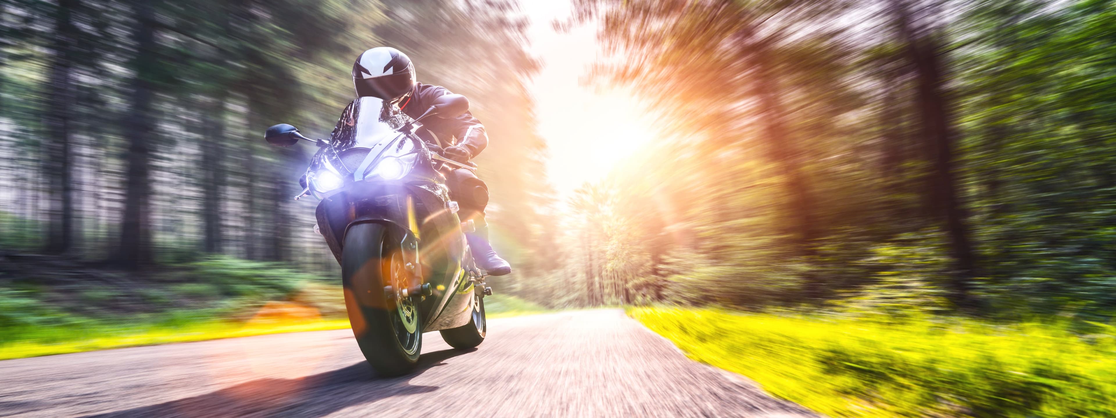 Motorcycle riding through a forest road